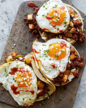 A close up of chorizo and fried egg breakfast tacos.