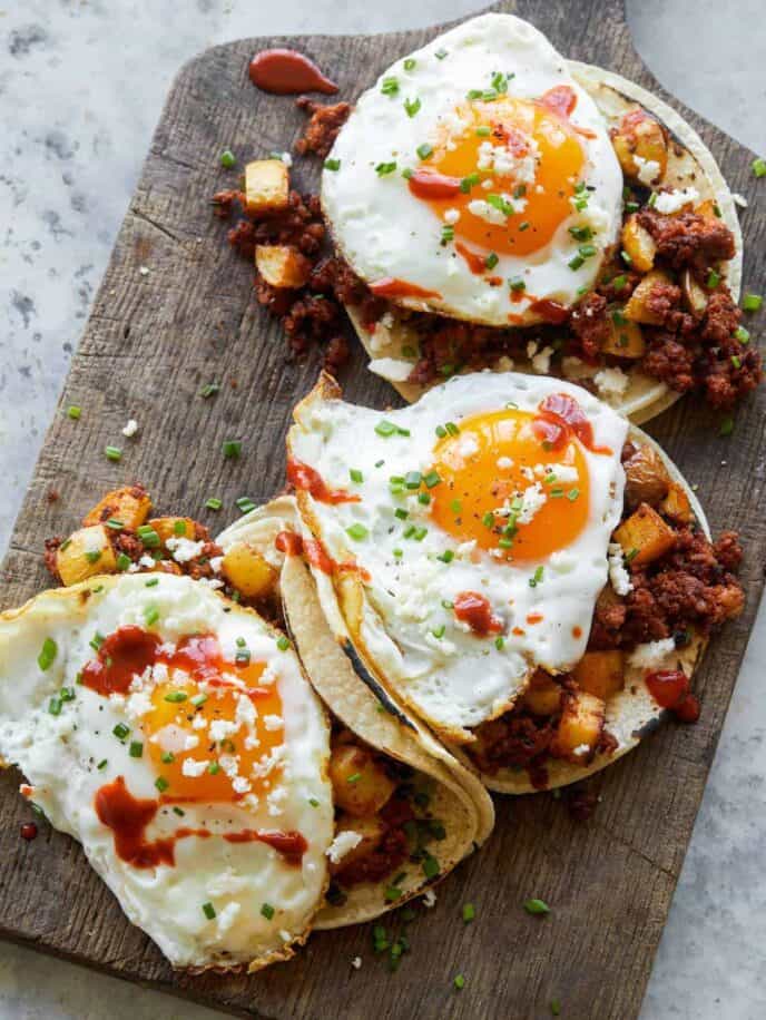 A close up of chorizo and fried egg breakfast tacos.