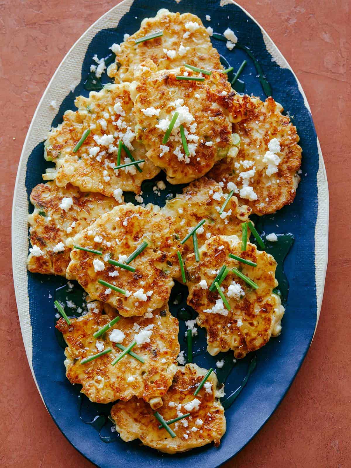 Jalapeño Corn Cakes on a platter drizzled with honey and ready to be served. 