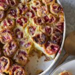 Strawberry and cinnamon French toast rollups with a serving spoon.