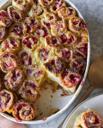 Strawberry and cinnamon French toast rollups with a serving spoon.