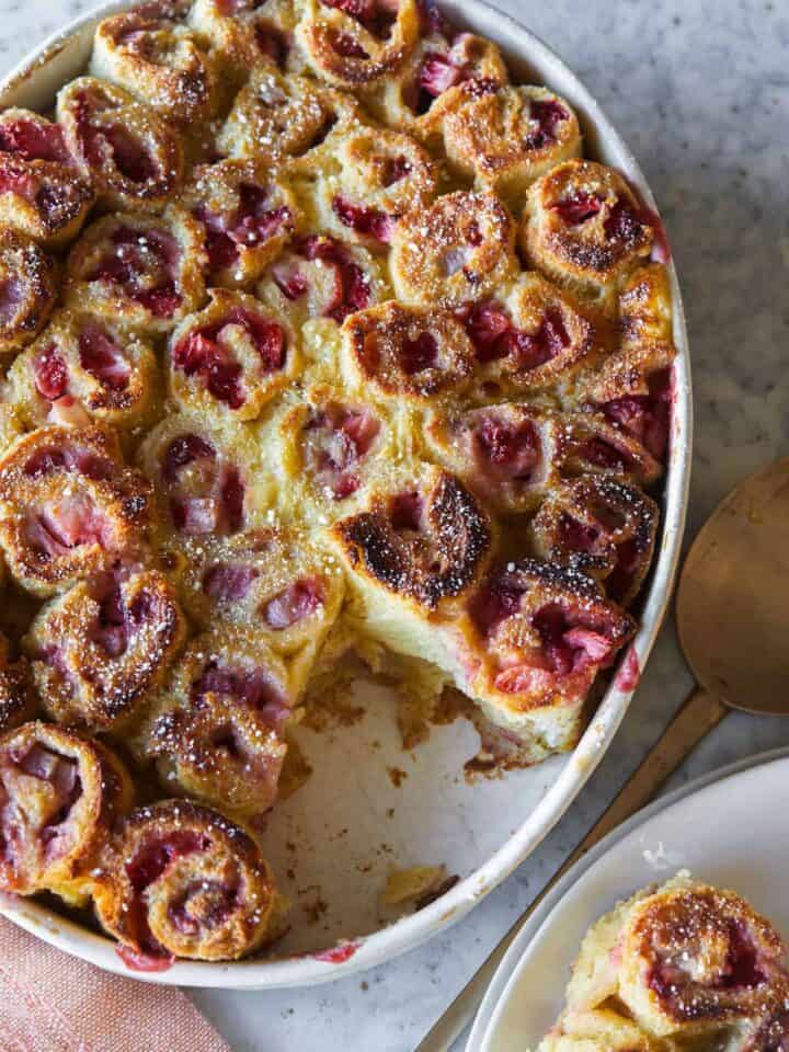 Strawberry and cinnamon French toast rollups with a serving spoon.