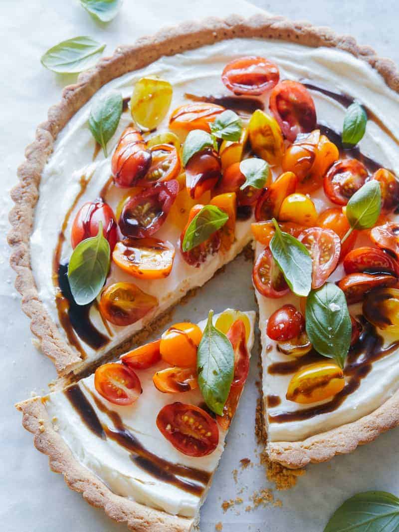 A bruschetta and whipped goat cheese tart with a slice cut out.