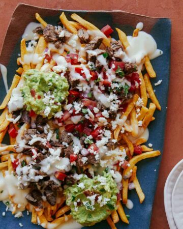Carne asada fries on a blue platter.