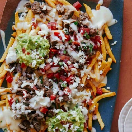 Carne asada fries on a blue platter.