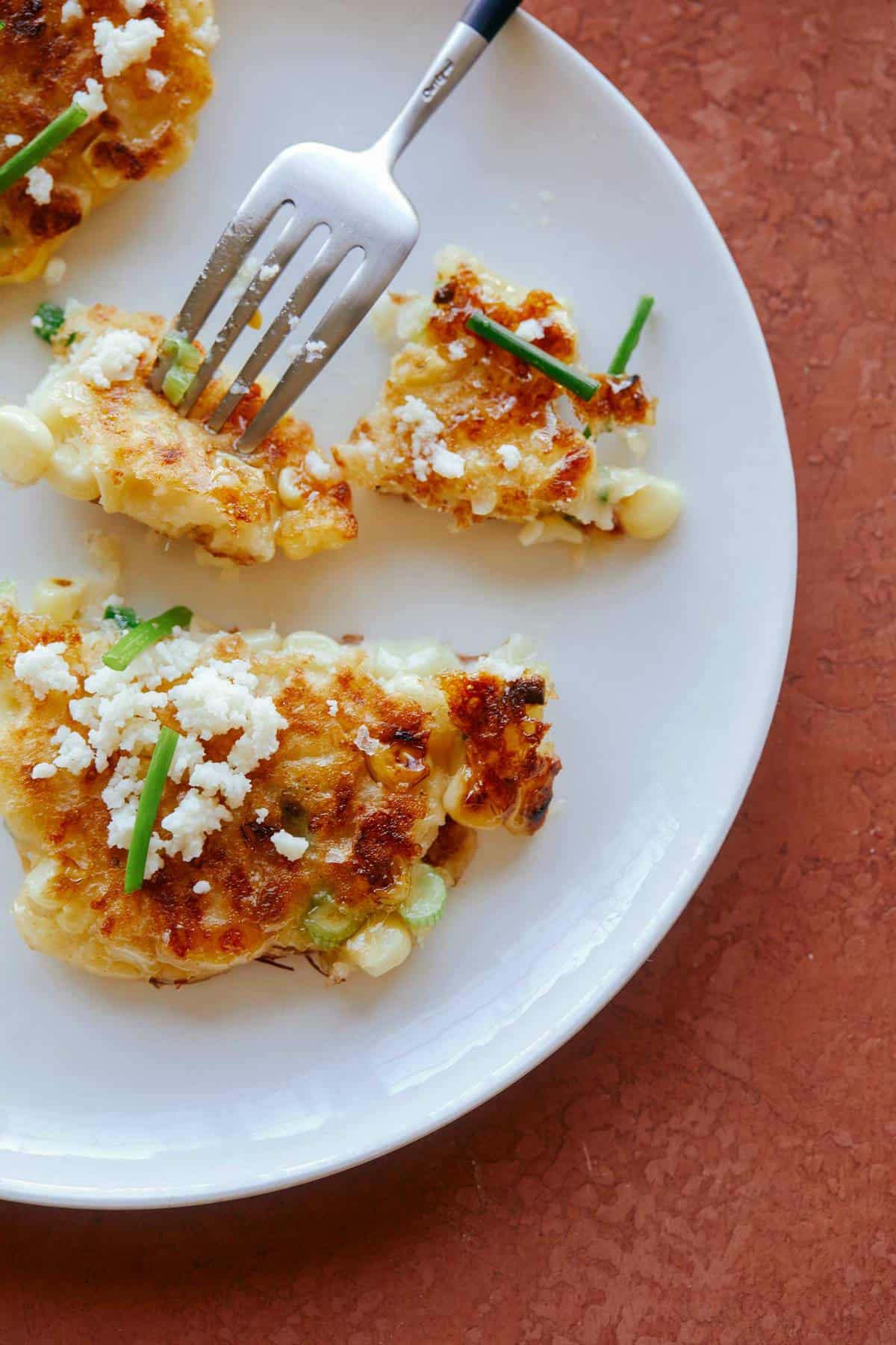 Jalapeño Corn Cakes cut open, being eaten with a fork in a piece.