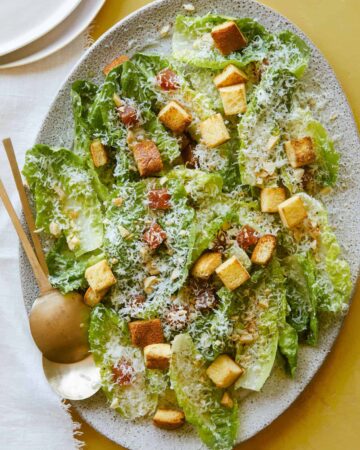 Simple salad with quince, manchego, and marcona almonds with serving spoons.