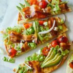 A sliced grilled BLTA flatbread.