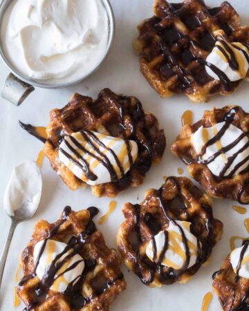 Liege waffles with whipped cream and a spoon on the side.