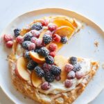 A summer fruit ricotta crostata with a slice removed.