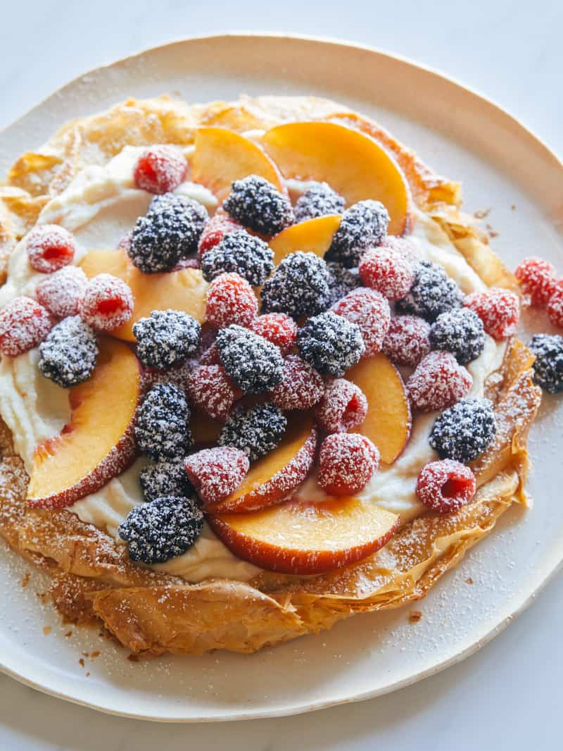 Summer fruit piles high on a bed of ricotta in a crostata. 