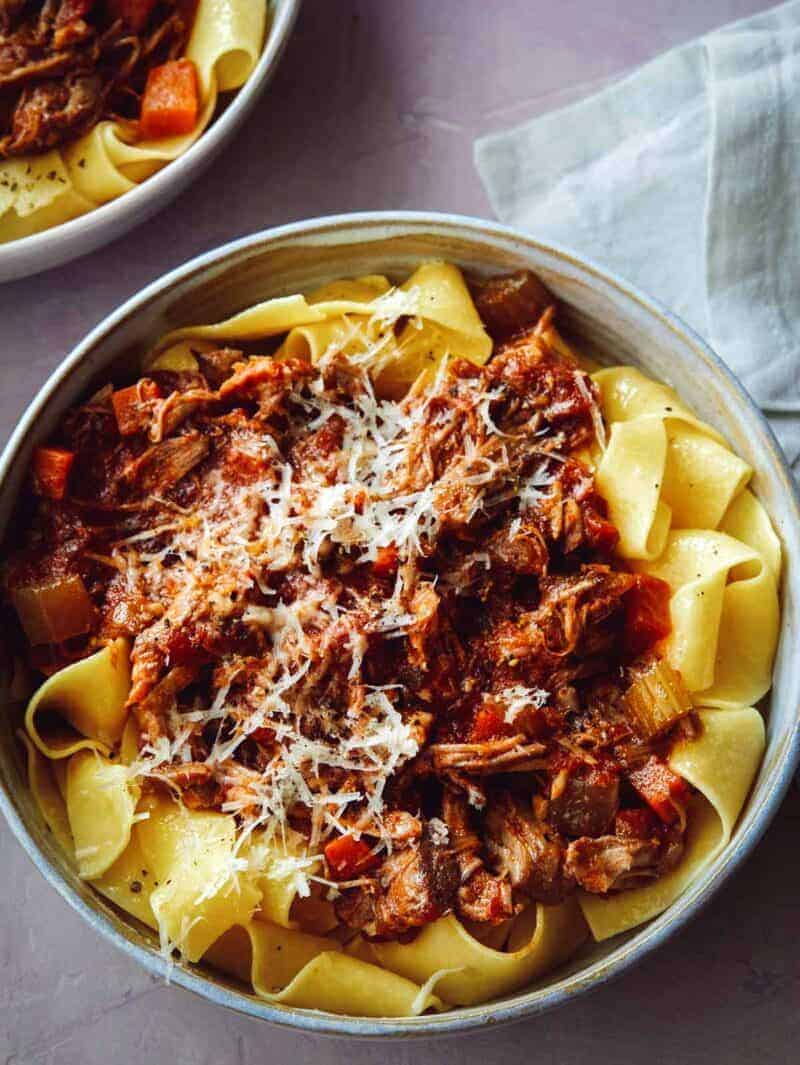 Braised Pork Ragu Pappardelle recipe, a close up on one bowl with parmesan on top.