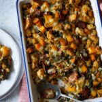 Butternut squash sage stuffing with a spoon and served on a plate.