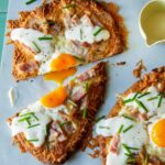 Croque madame flatbread, cut in half with a runny egg yolk.