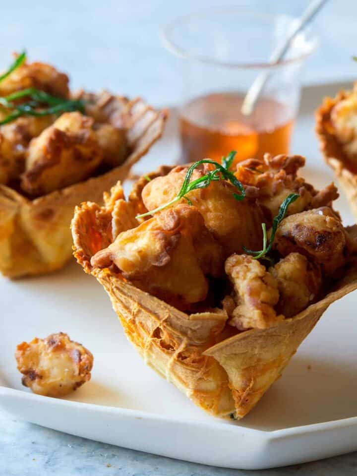 A close up of popcorn chicken in cheesy waffle cups.