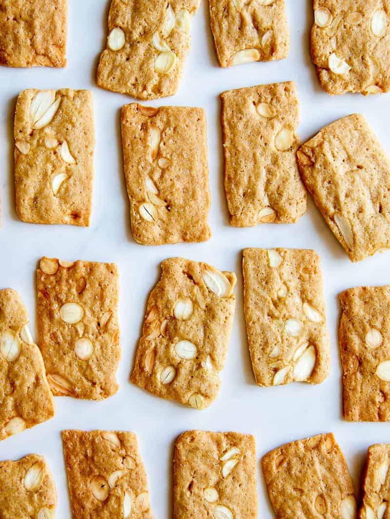 A close up of almond thin cookies laid out in rows.