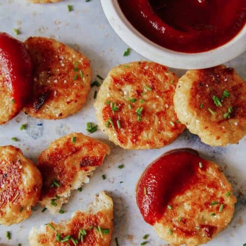 A close up of crispy baked cauliflower tots with sauce.