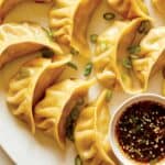 Ginger chicken pot stickers with green onions and sauce on the side.