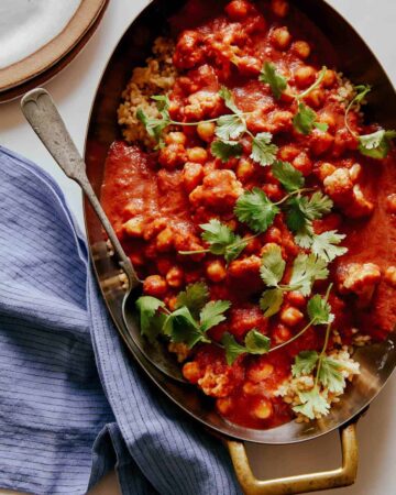 Spicy vegan chickpea and cauliflower curry with a spoon.