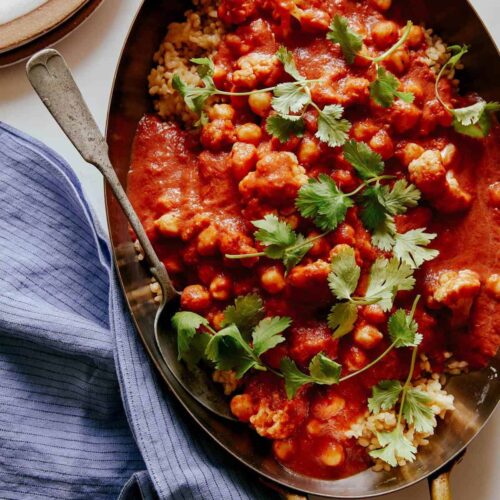 Spicy vegan chickpea and cauliflower curry with a spoon.