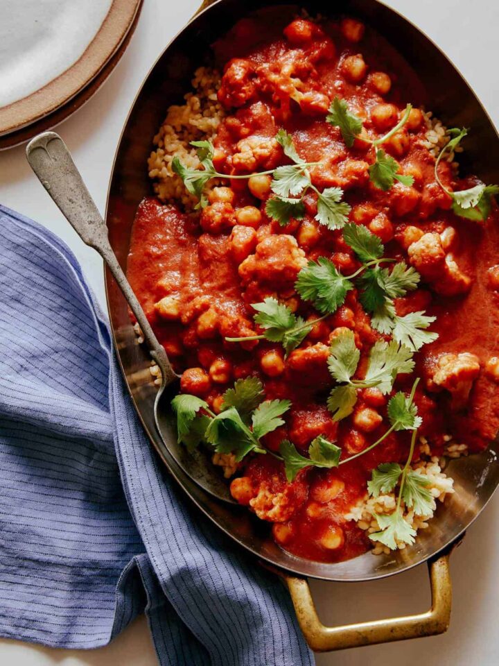 Spicy vegan chickpea and cauliflower curry with a spoon.