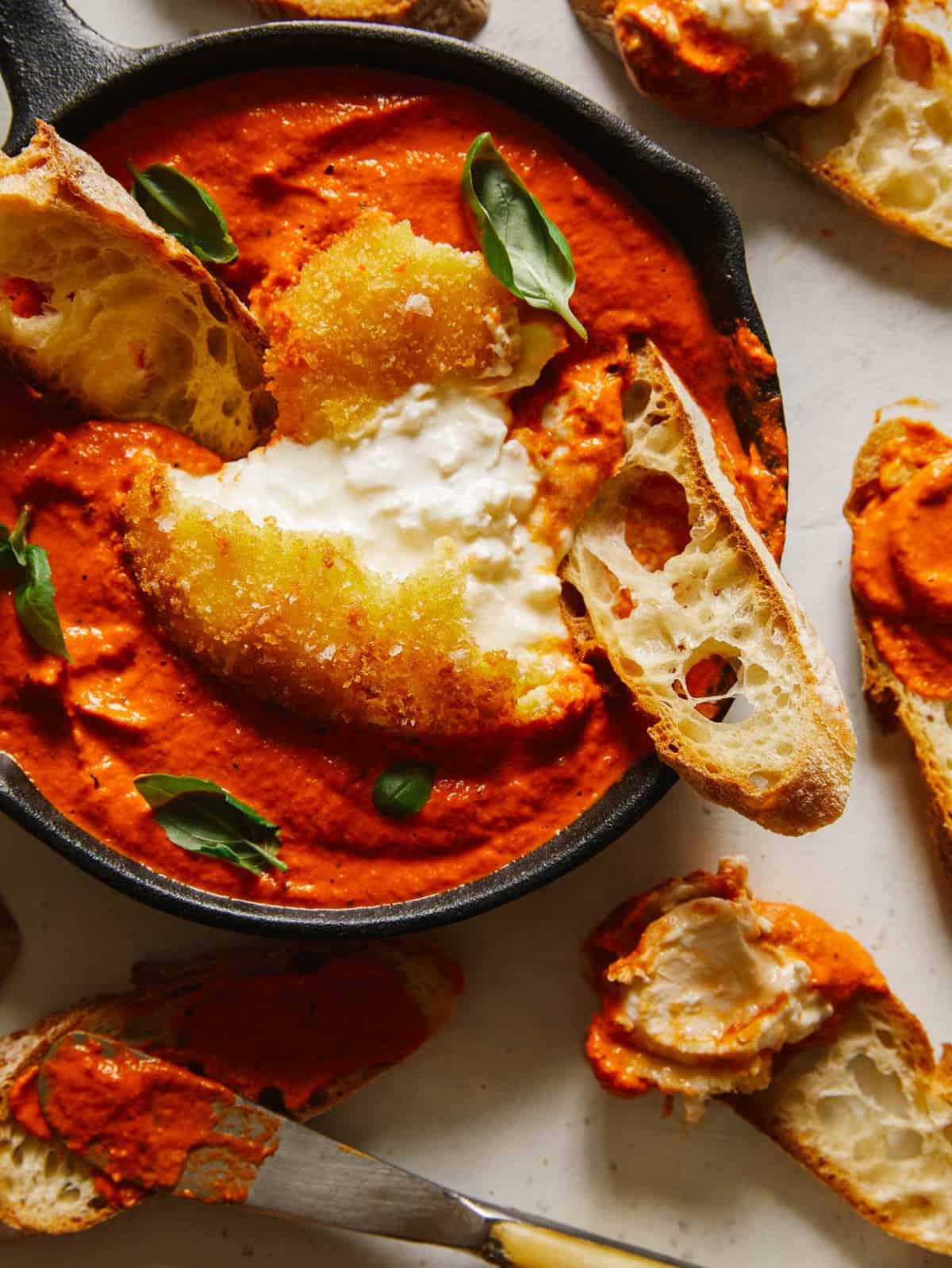 A close up of a bowl of fried burrata romesco and bread.