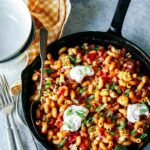 Taco pasta in a skillet with a spoon and forks.
