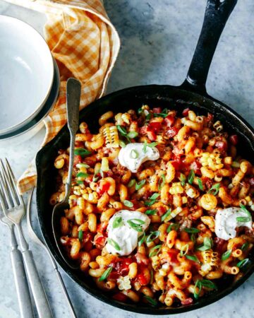 Taco pasta in a skillet with a spoon and forks.