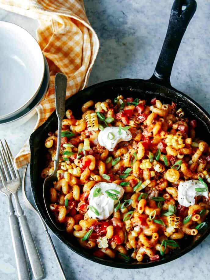 Taco pasta in a skillet with a spoon and forks.