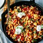 Taco pasta skillet recipe with bowls on the side.