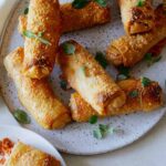A close up of crispy baked pepperoni pizza egg rolls.
