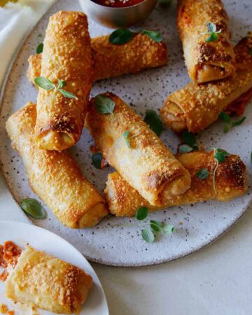 A close up of crispy baked pepperoni pizza egg rolls.
