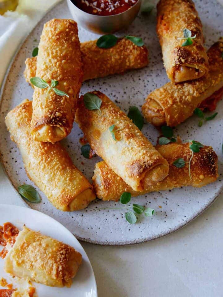 A close up of crispy baked pepperoni pizza egg rolls.
