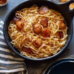 Linguine with brown butter sauce and scallops in a skillet.