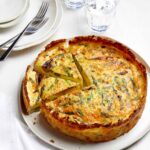 A sliced spring quiche with hash brown crust.