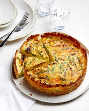 A sliced spring quiche with hash brown crust.