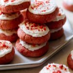 A close up of soft and fluffy strawberry cookies with vanilla frosting.