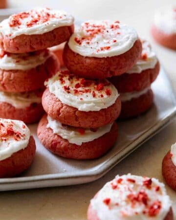A close up of soft and fluffy strawberry cookies with vanilla frosting.