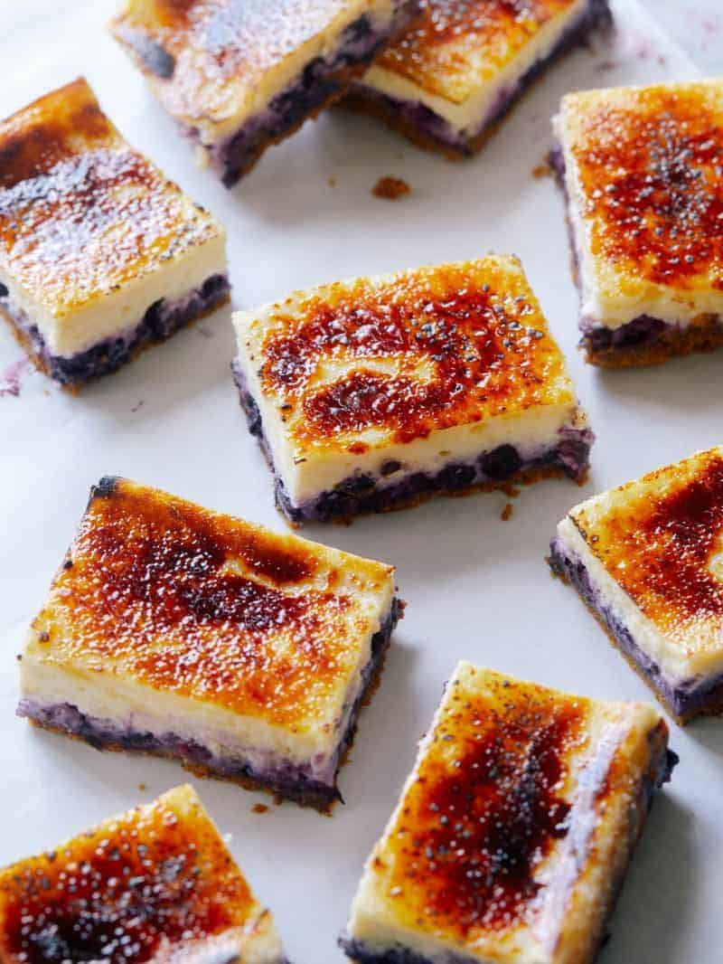 A close up of several blueberry cheesecake bars.