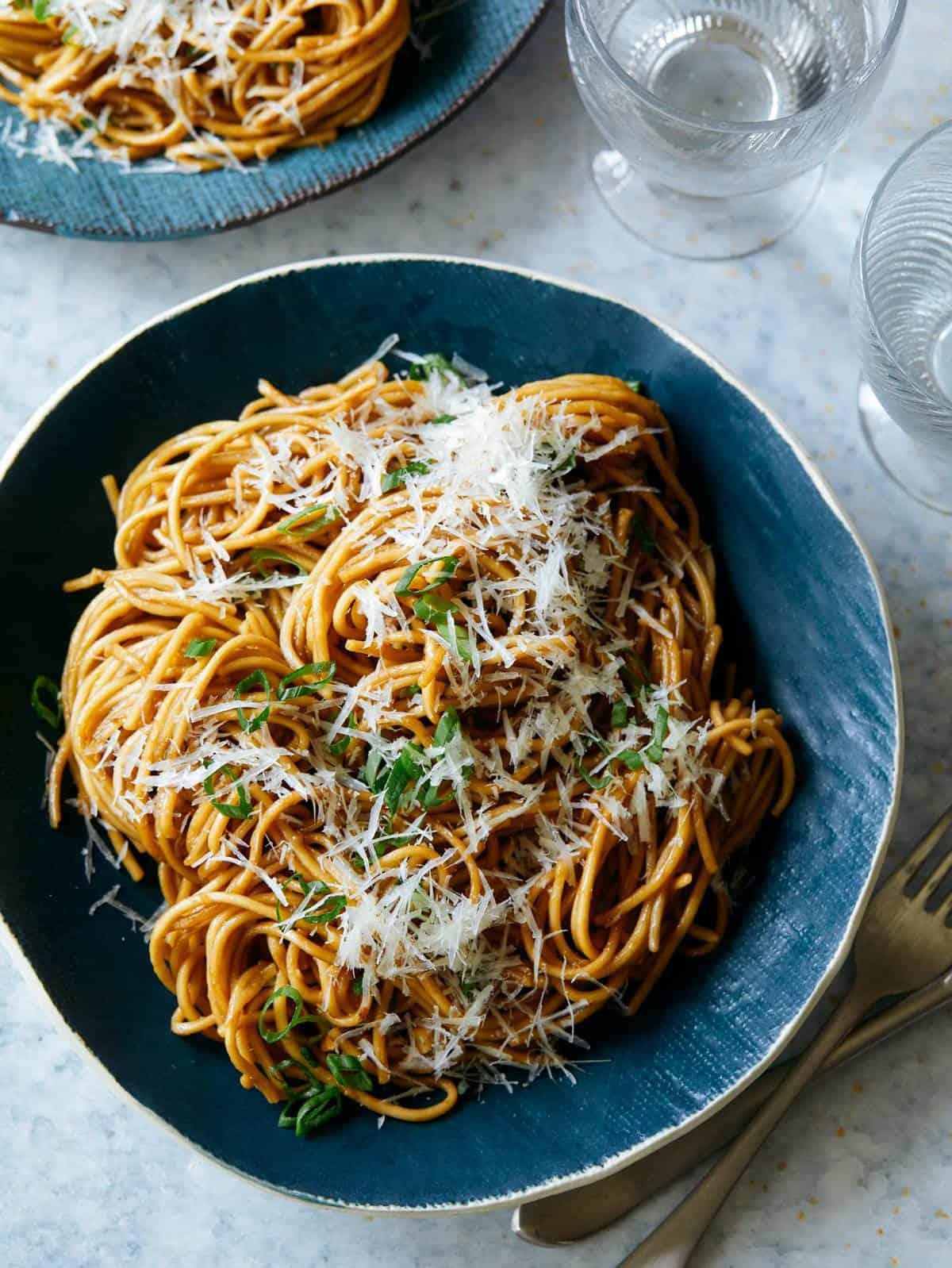 Finished bowl of garlic noodles with another bowl of noodles peaking in at the top