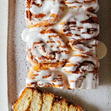 A frosted cinnamon roll loaf with the end sliced off.