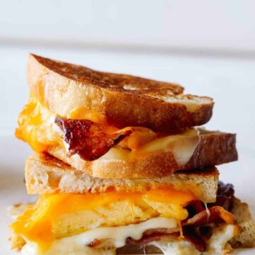 A close up of stacked extra cheesy breakfast grilled cheese sandwiches.