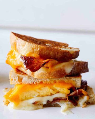 A close up of stacked extra cheesy breakfast grilled cheese sandwiches.