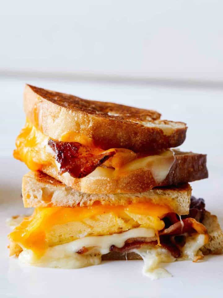 A close up of stacked extra cheesy breakfast grilled cheese sandwiches.
