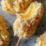 A close up of cookie coated mango Lassi frozen yogurt bar with a bite out.