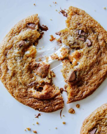 A close up of a marshmallow stuffed S'more cookie broken in half.