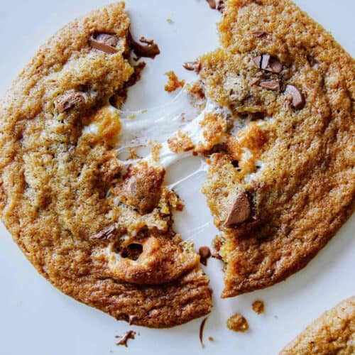 A close up of a marshmallow stuffed S'more cookie broken in half.