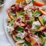 A close up of heirloom tomato, peach, and burrata summer plate.