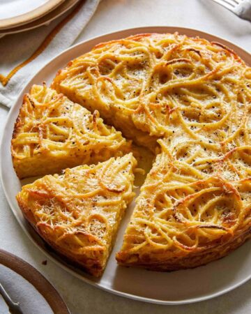 Cacio e pepe pasta pie with slices cut.