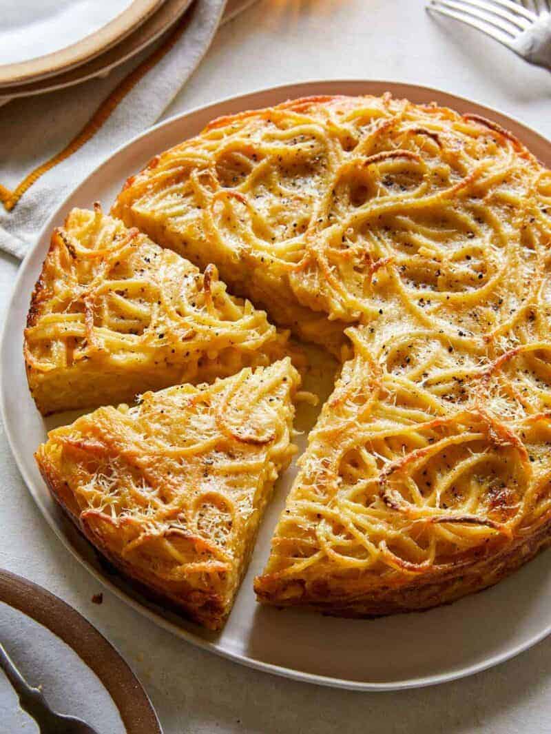 Cacio e pepe pasta pie with slices cut.